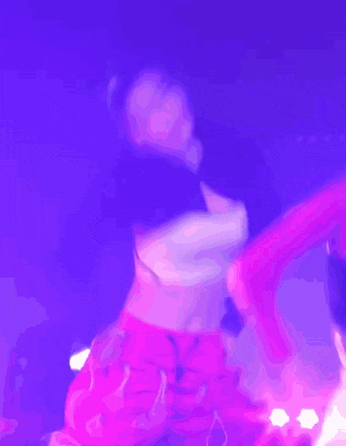 a woman in a white top and pink pants is dancing on a stage
