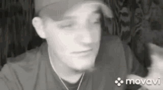 a black and white photo of a man wearing a baseball cap