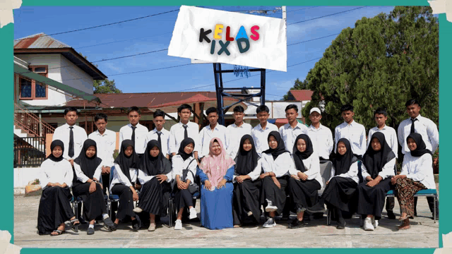 a group of people posing for a photo with a sign that says kelas