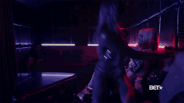 two women hugging in a dark room with a bet logo