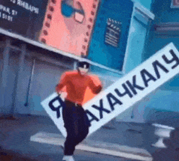 a man in a red sweater is holding a sign that says ' a ' on it