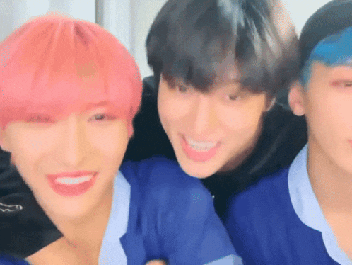 a group of young men with pink hair are smiling for the camera
