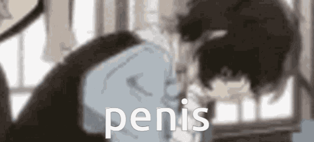 a blurry picture of a man laying down with the word penis written on the bottom .