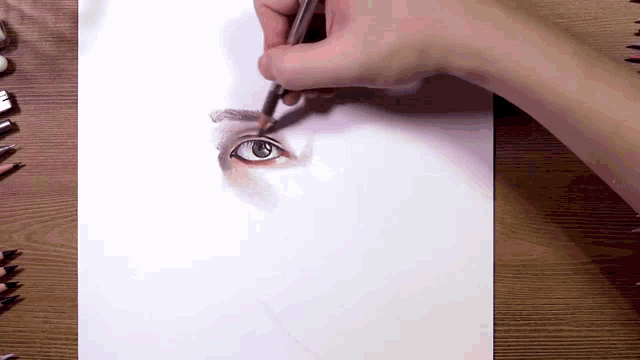 a person is drawing an eye with a pencil