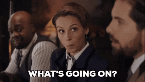 a woman says what 's going on in front of a group of men