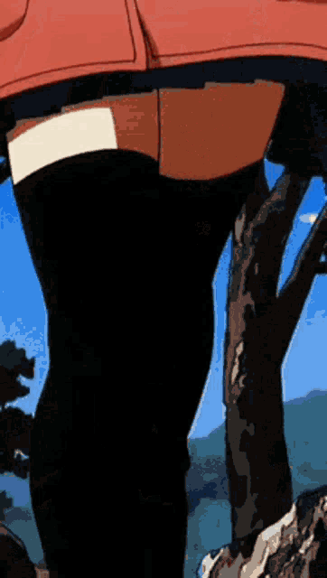 a woman in thigh high socks is standing next to a tree in a forest .