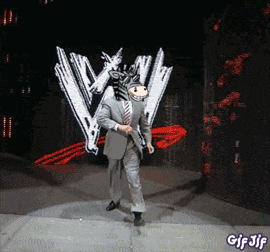 a man in a suit is dancing in front of a wrestling logo