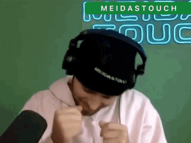 a man wearing headphones and a beanie with the word meidas on it