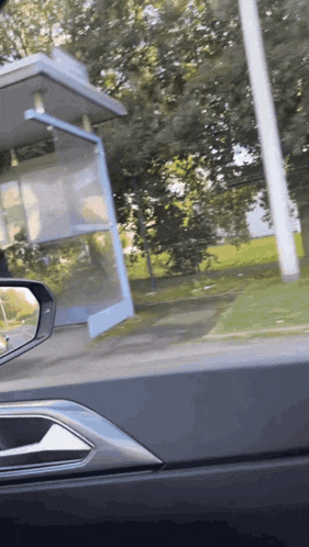 a bus stop is visible in the rear view mirror of a vehicle