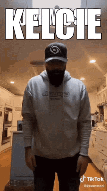 a man wearing a hat and a hoodie that says kelcie on it