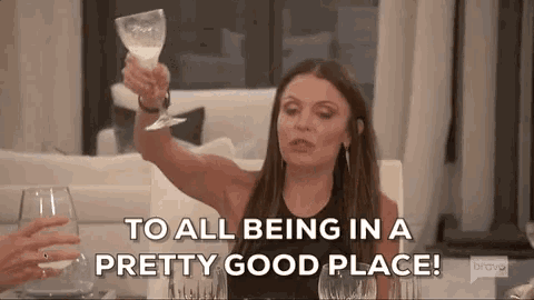 a woman is holding a wine glass and says to all being in a pretty good place