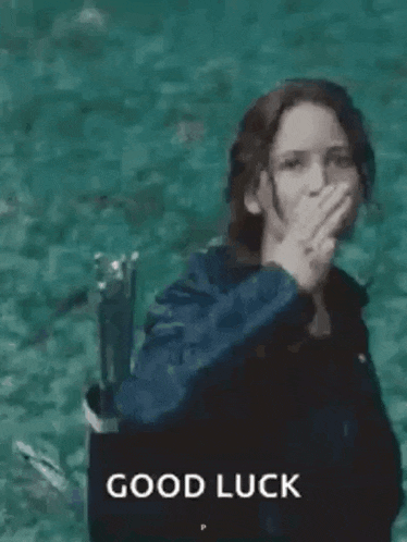 a woman in a black jacket is giving the middle finger in front of a body of water .