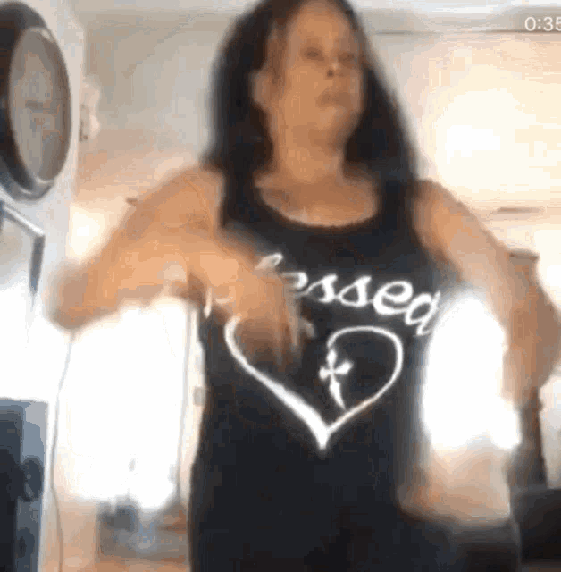 a woman wearing a black tank top that says blessed on it