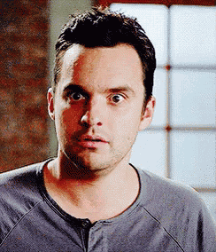 a man in a gray shirt is making a funny face .