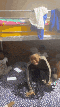 a boy is sitting on a bunk bed making a funny face .