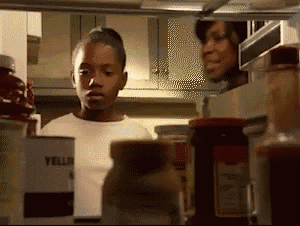 a young boy looking into a refrigerator with a can of yellow mustard on the shelf