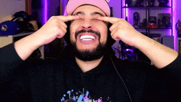 a man with a beard wearing a pink hat is covering his eyes with his fingers