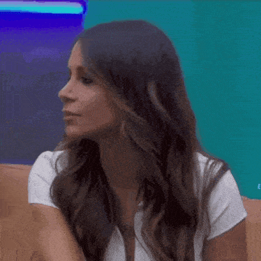a woman in a white shirt is crossing her arms in front of her face .
