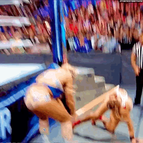 a wrestling match is being shown on a screen with the hashtag #thenextbig thing