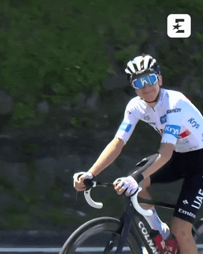 a man riding a bike with a jersey that says uae