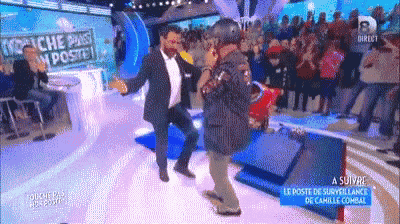 a man in a suit is dancing on a stage in front of a crowd with a sign that says " marche pas en poste "