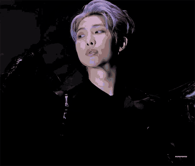 a close up of a person with purple hair and a black jacket