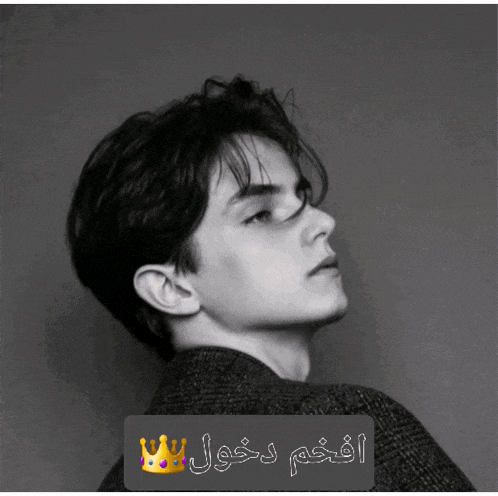 a black and white photo of a young man with a crown on his head with arabic writing