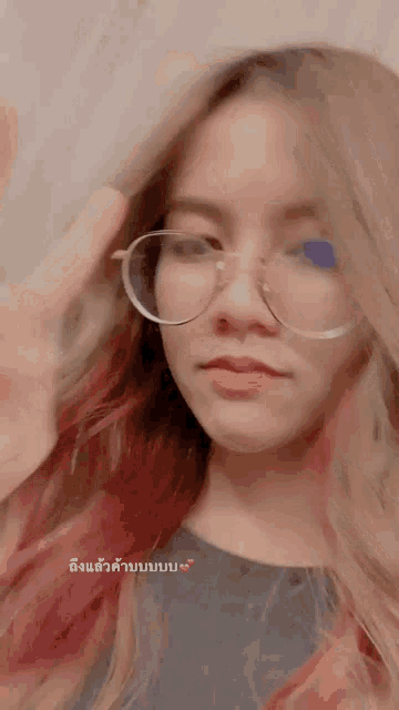 a woman wearing glasses and a black shirt has a pink heart in the corner