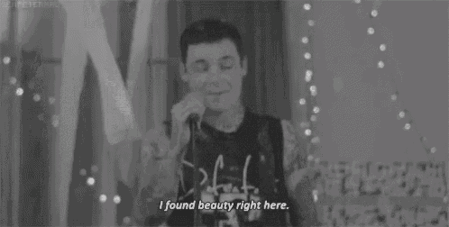 a man is singing into a microphone and says `` i found beauty right here '' .