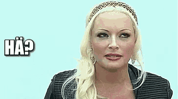 a woman with blonde hair and a headband is making a funny face and has the word ha written above her .