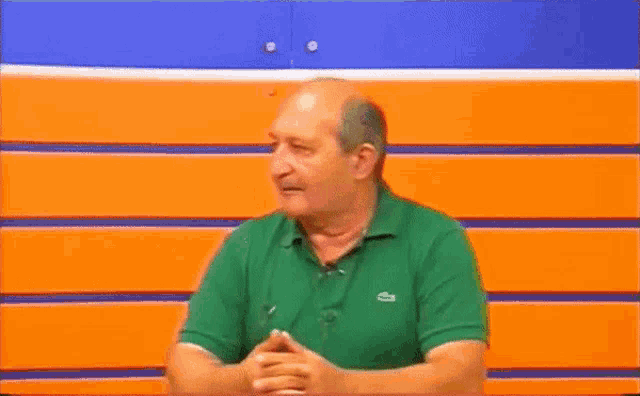 a man in a green shirt is sitting in front of a wall with the words elementare vuotson on it