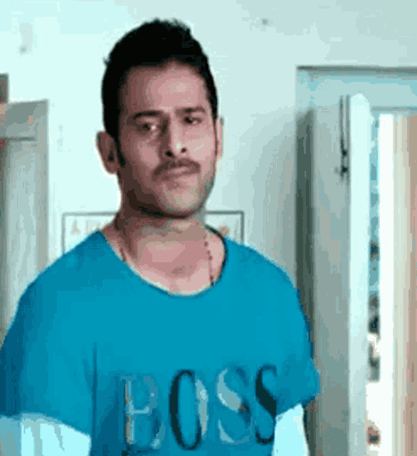a man wearing a blue t-shirt with the word boss on it .
