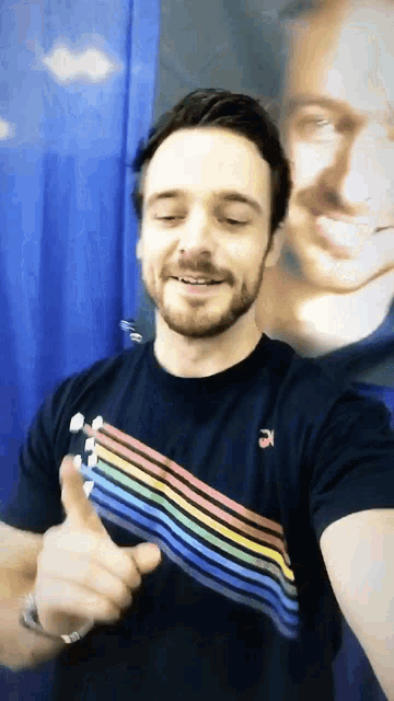 a man wearing a black shirt with a rainbow stripe on it