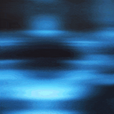 a blurry picture of a dark blue background with a few lights coming out of it