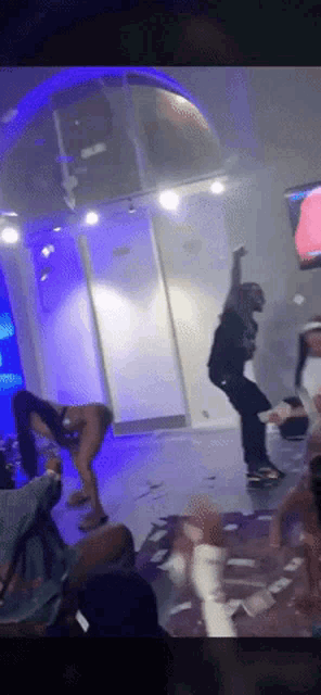 a group of people are dancing in a room with a sign that says ' a ' on it