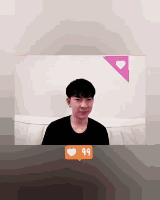a man sitting on a couch with a pink heart and the number 99