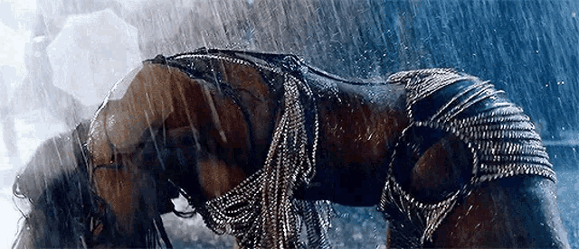 a woman in a bikini is bending over in the rain