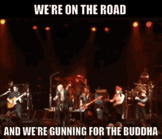 a man playing a guitar on a stage with the words we 're on the road and we 're gunning for the buddha