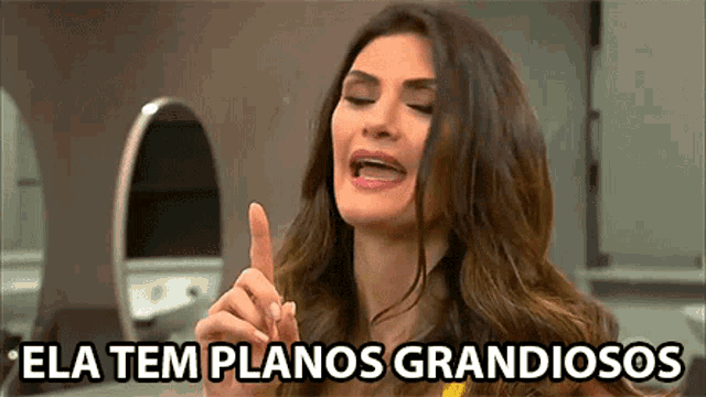 a woman is making a funny face and says ela tem planos grandiosos in a foreign language .