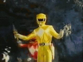 a yellow power ranger is holding a knife and a sword .