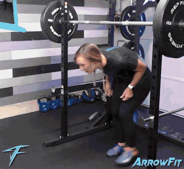 a woman is doing squats in a gym with arrowfit written on the floor