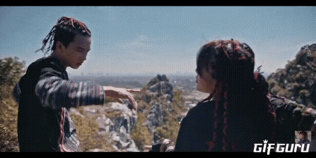 a man and a woman are standing on top of a mountain and the words gif guru are on the bottom of the screen