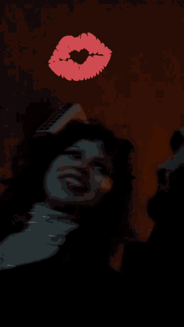 a woman laying down with a red heart shaped kiss on her face