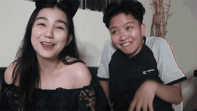 a girl wearing cat ears and a boy wearing a champion t-shirt