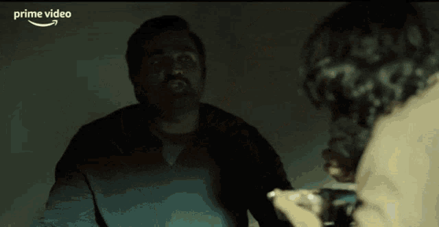 a man with a beard is eating from a tin foil container and the word prime video is on the bottom right