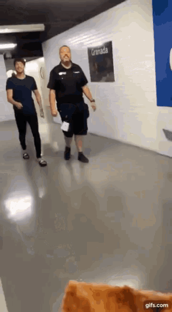 two men walking down a hallway with a sign that says granada
