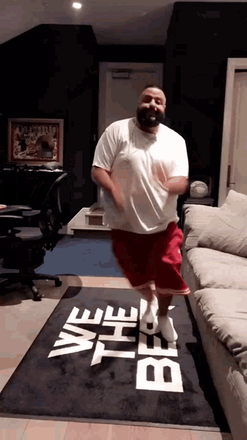 a man is jumping in the air in front of a rug that says we the best