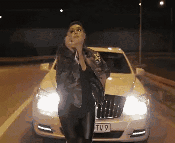 a woman standing in front of a white car with a license plate that says tv9