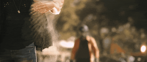 a person is spraying something from their hands in a blurry picture
