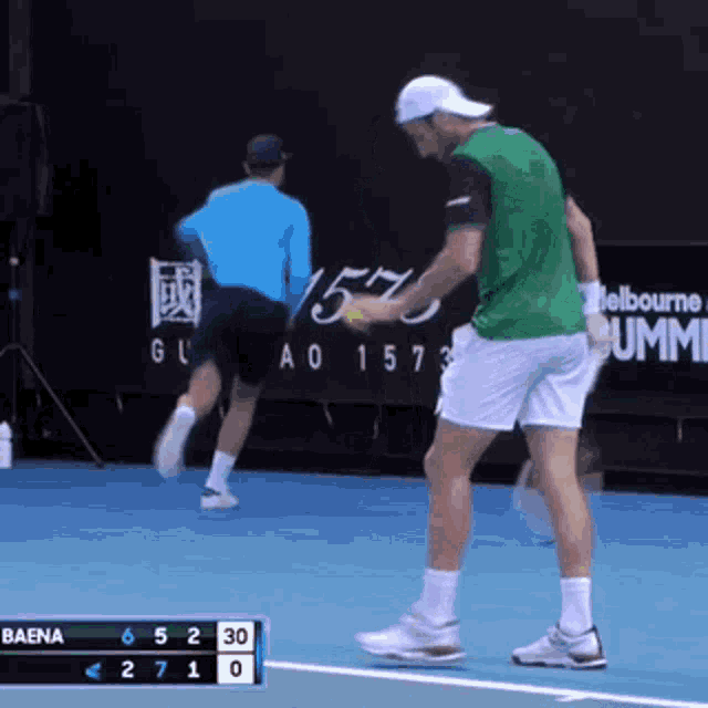 a man in a green shirt is holding a tennis ball while playing tennis